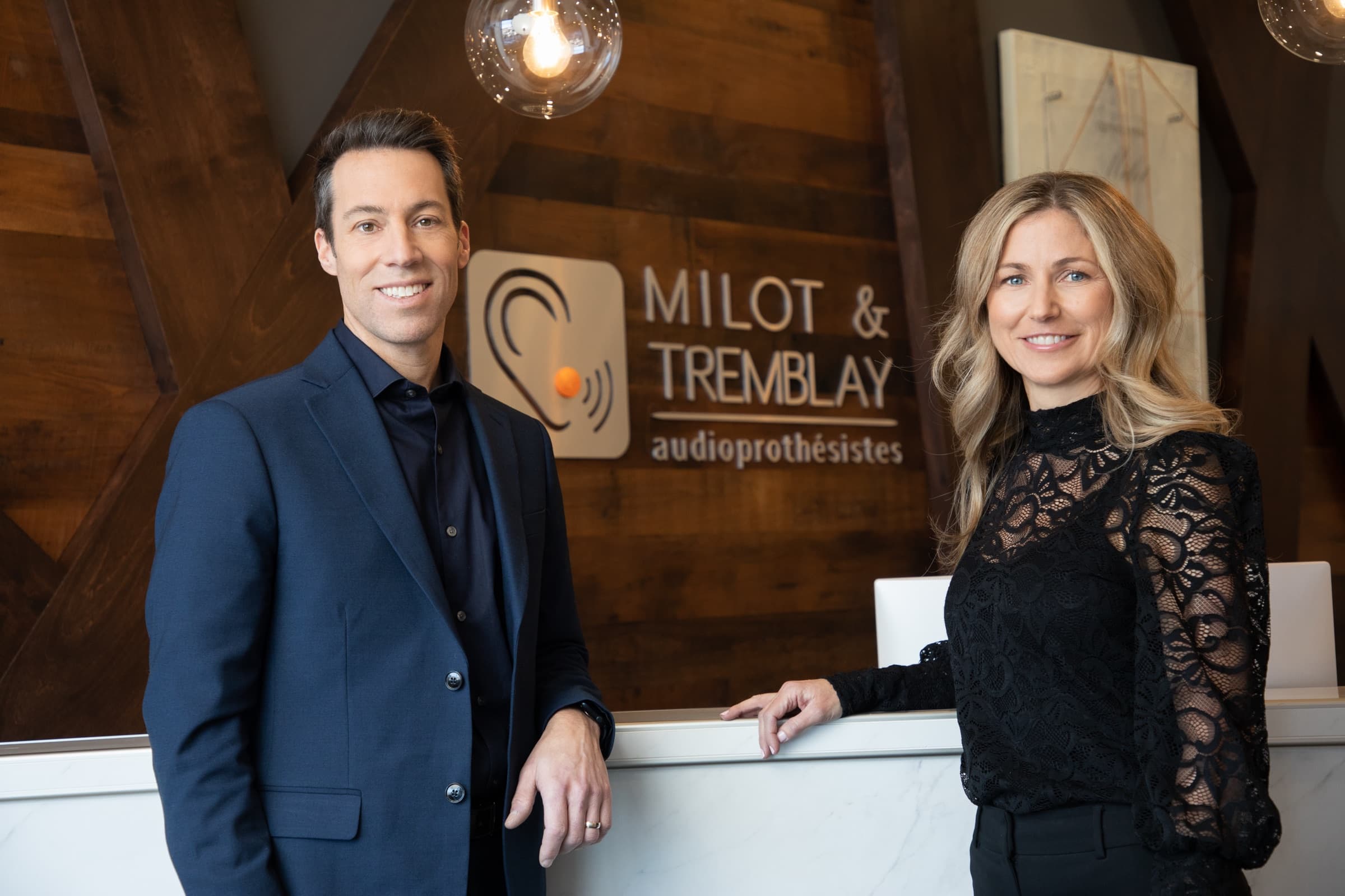 L'équipe de Milot & Tremblay audioprothésistes devant l'enseigne de la clinique