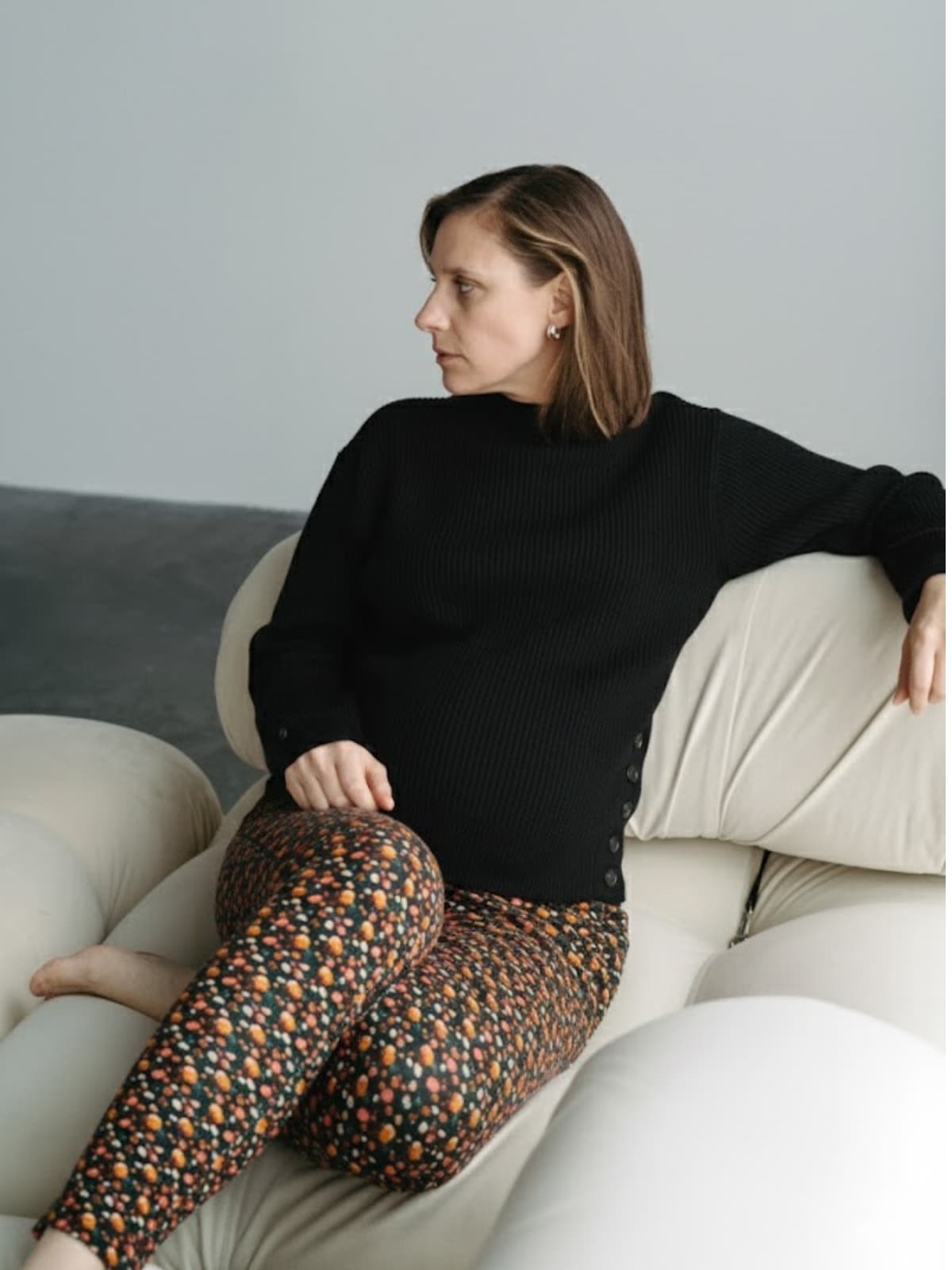 Femme enceinte portant un tricot noir et un legging de maternité à motifs Solveig